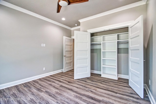 unfurnished bedroom with wood-type flooring, a textured ceiling, a closet, ceiling fan, and crown molding