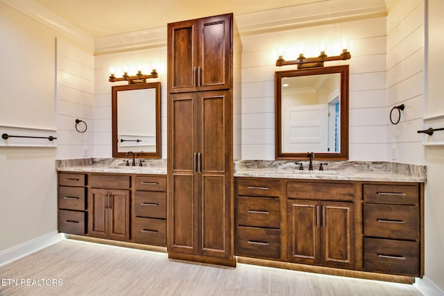 bathroom with vanity, crown molding, and hardwood / wood-style flooring