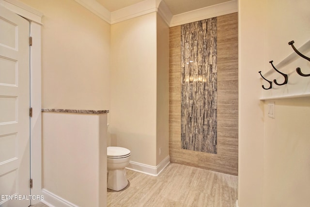 bathroom featuring ornamental molding, toilet, baseboards, and wood finished floors