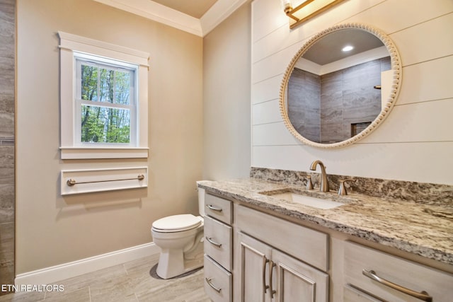 bathroom with baseboards, toilet, ornamental molding, a tile shower, and vanity