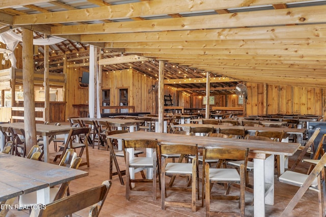 dining area with wooden walls and vaulted ceiling