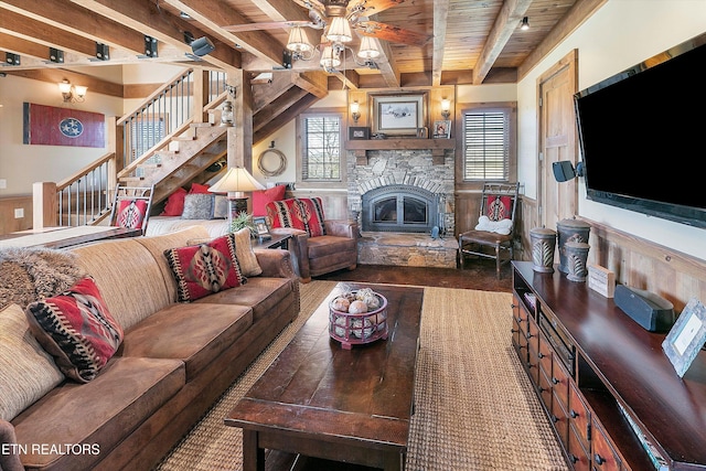 living room with wood ceiling, beamed ceiling, a fireplace, and ceiling fan