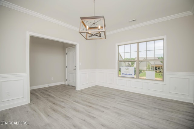 unfurnished dining area with visible vents, wood finished floors, a chandelier, and crown molding