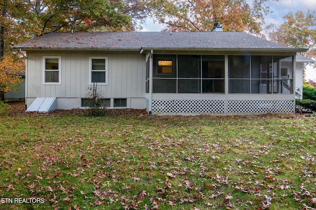 rear view of property with a yard and a sunroom