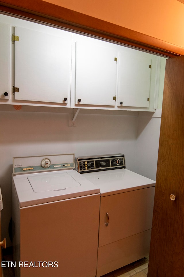 clothes washing area with washing machine and dryer and cabinets