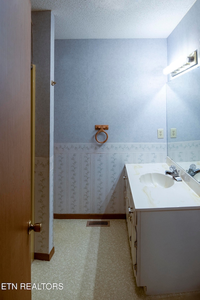 bathroom with a textured ceiling and vanity