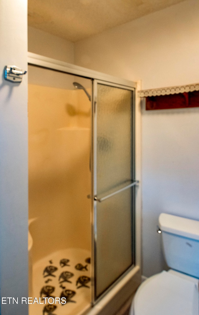 bathroom featuring an enclosed shower and toilet