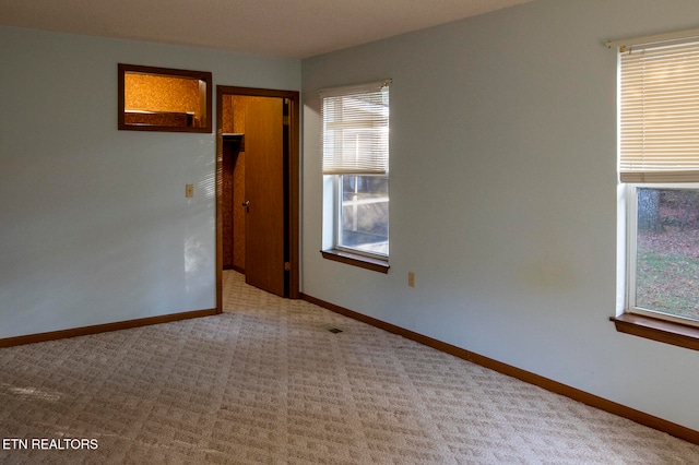 carpeted spare room with a healthy amount of sunlight