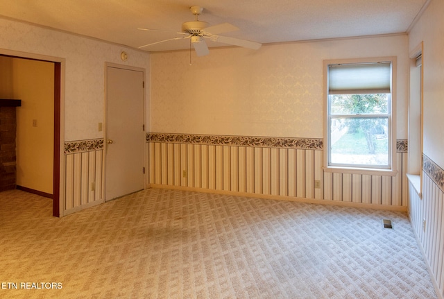 spare room featuring carpet flooring, ceiling fan, and ornamental molding