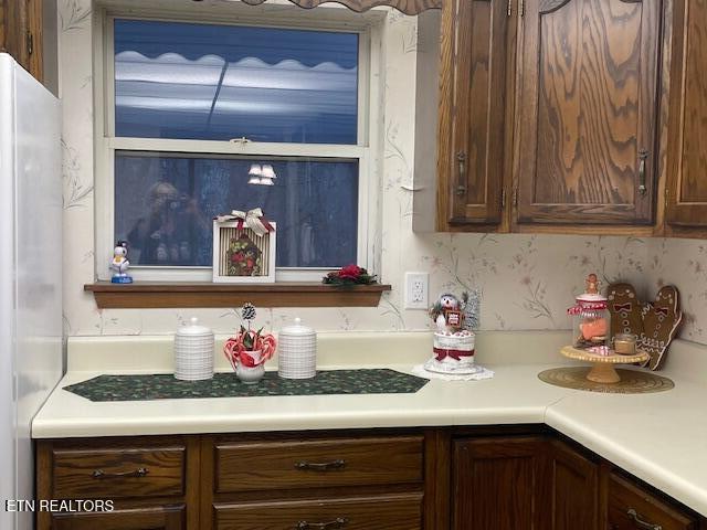 kitchen featuring dark brown cabinets and refrigerator