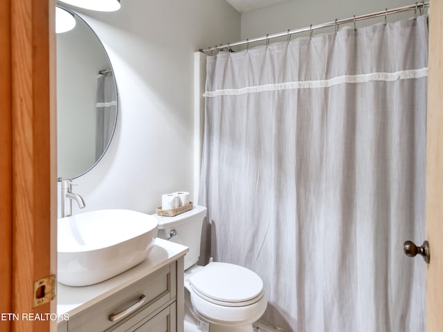 bathroom featuring vanity, toilet, and walk in shower