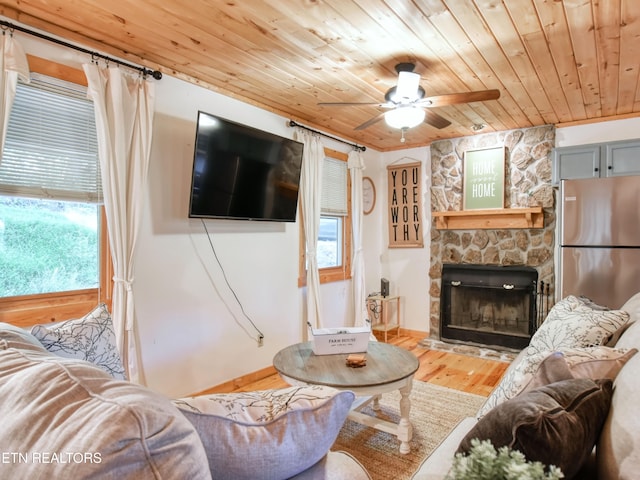 living room featuring a fireplace, wood ceiling, wood-type flooring, and ceiling fan