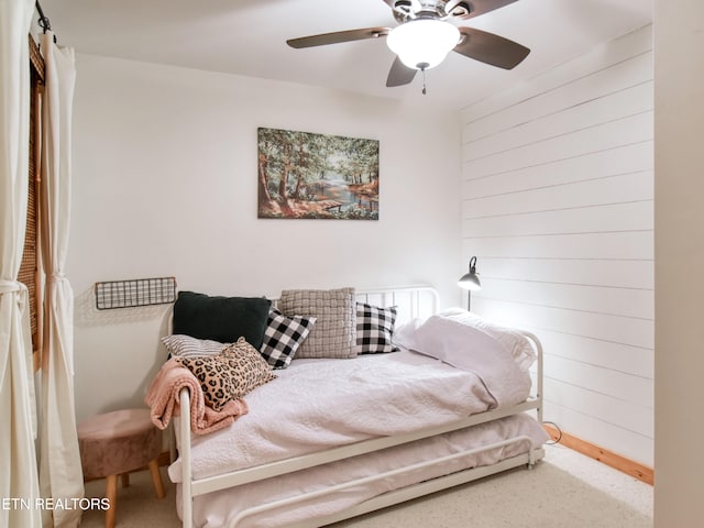 bedroom with wood walls and ceiling fan