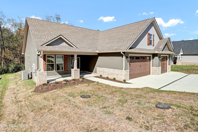 craftsman inspired home featuring a front yard, central AC, covered porch, and a garage