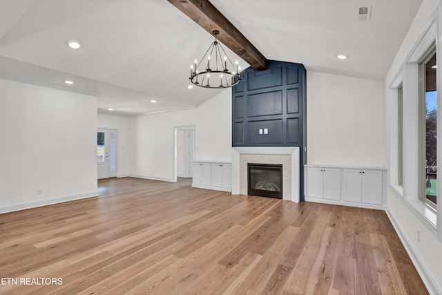 unfurnished living room featuring a healthy amount of sunlight, lofted ceiling with beams, a chandelier, and light wood-type flooring