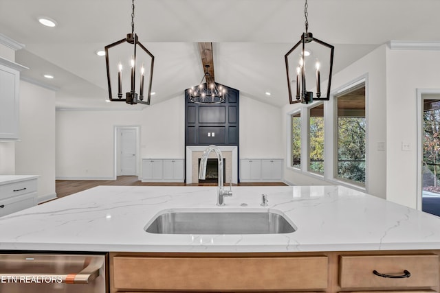 kitchen with lofted ceiling with beams, light stone countertops, sink, and pendant lighting