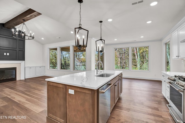 kitchen featuring appliances with stainless steel finishes, white cabinetry, sink, and light hardwood / wood-style floors