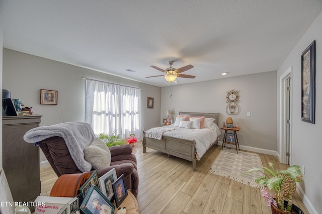 bedroom featuring a textured ceiling, light hardwood / wood-style floors, and ceiling fan