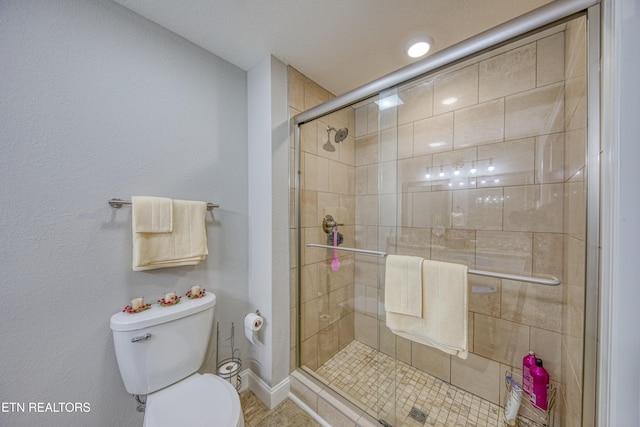 bathroom with toilet, a shower with shower door, and tile patterned flooring