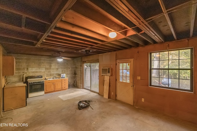 basement with ceiling fan, a wall mounted AC, and sink