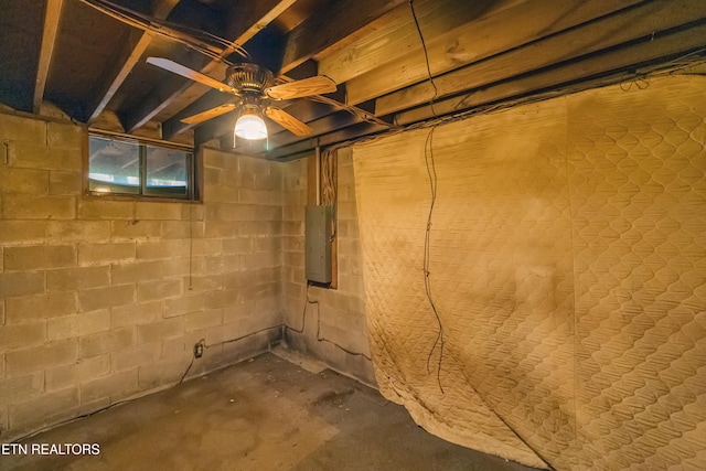 basement with ceiling fan and electric panel