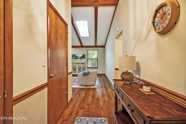 corridor featuring vaulted ceiling with skylight and dark hardwood / wood-style flooring