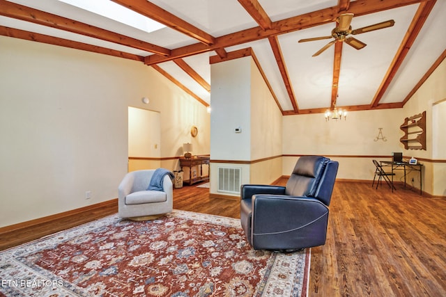 sitting room with lofted ceiling with skylight, hardwood / wood-style floors, and ceiling fan with notable chandelier