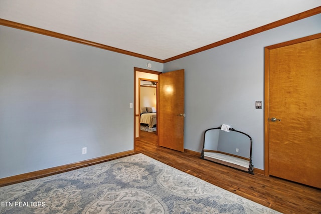 unfurnished bedroom with crown molding and dark hardwood / wood-style floors