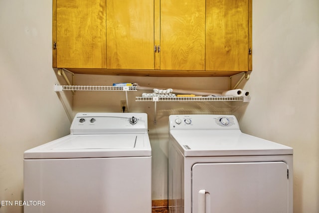 laundry room featuring independent washer and dryer and cabinets