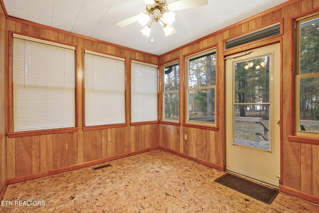 unfurnished sunroom featuring ceiling fan