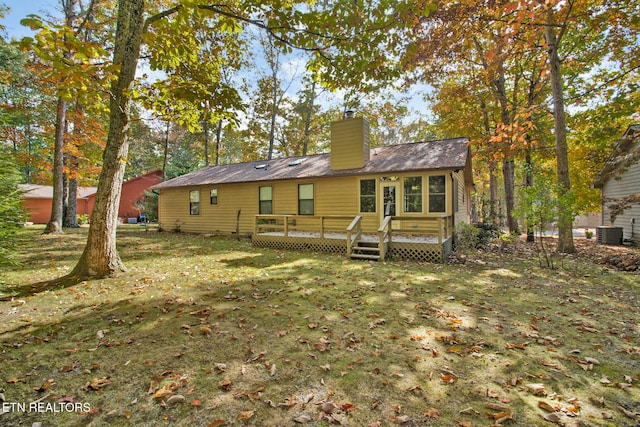 rear view of house with a deck, central AC unit, and a lawn