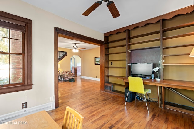 office area featuring built in desk, ceiling fan, and hardwood / wood-style flooring