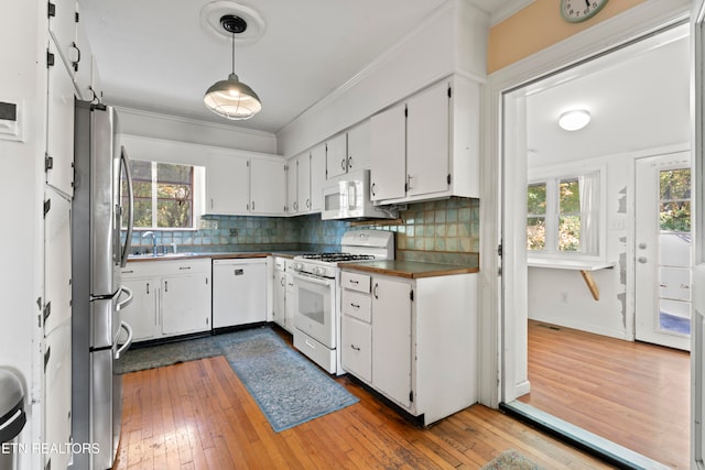 kitchen with white cabinets, hardwood / wood-style floors, pendant lighting, and white appliances