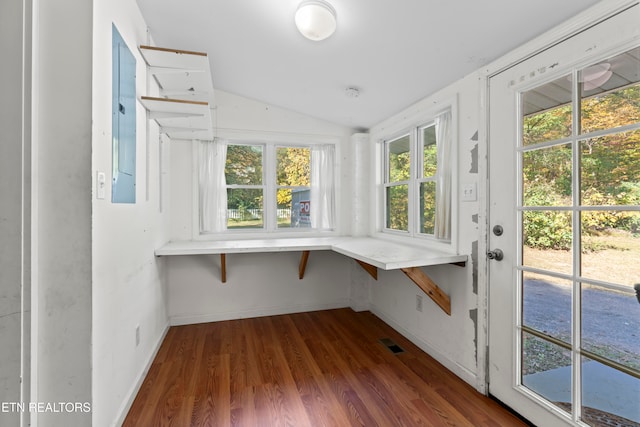 unfurnished sunroom featuring electric panel and lofted ceiling