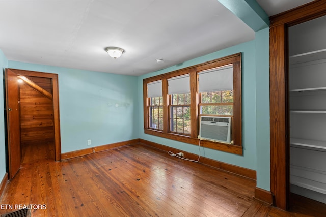 unfurnished bedroom featuring wood-type flooring and cooling unit