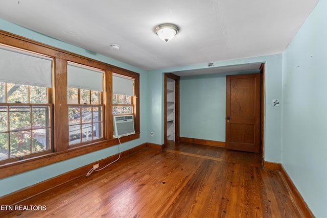 empty room with cooling unit and wood-type flooring