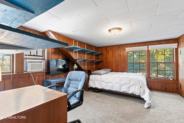 bedroom featuring multiple windows and wood walls