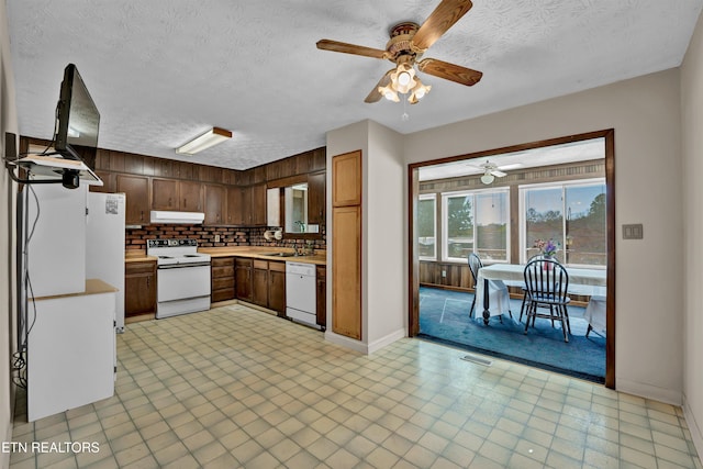 kitchen featuring decorative backsplash, a textured ceiling, white appliances, and ceiling fan