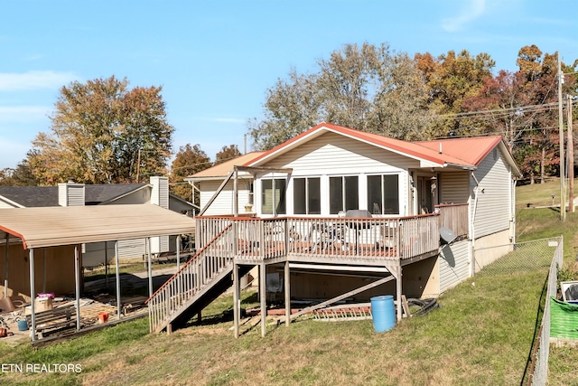 rear view of property with a yard, a sunroom, and a deck