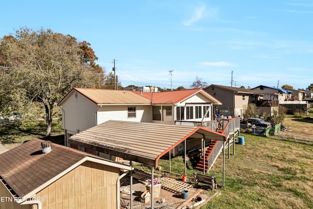 back of house with a lawn and a sunroom