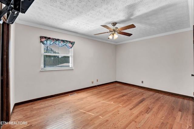 empty room with ceiling fan, a textured ceiling, ornamental molding, and hardwood / wood-style floors