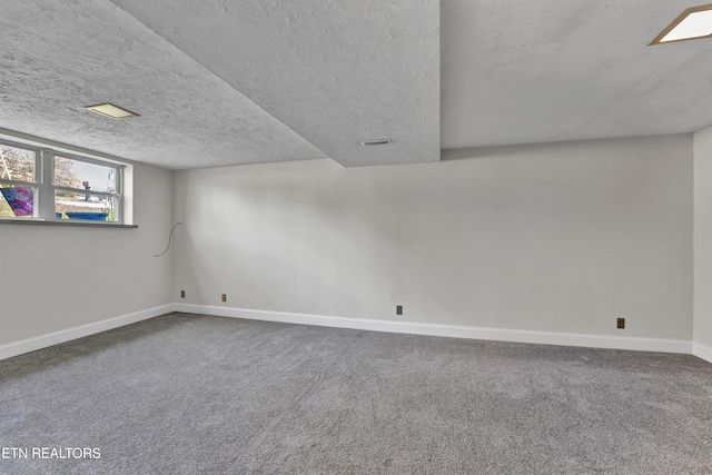 basement featuring a textured ceiling and carpet floors