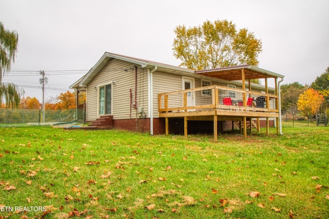 rear view of property with a deck and a lawn