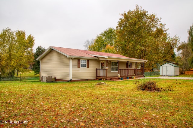 view of front of property with central AC unit, a shed, and a front lawn