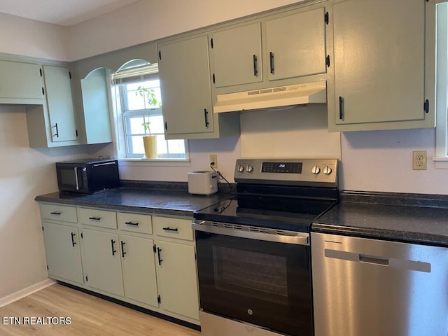 kitchen with appliances with stainless steel finishes and light hardwood / wood-style floors