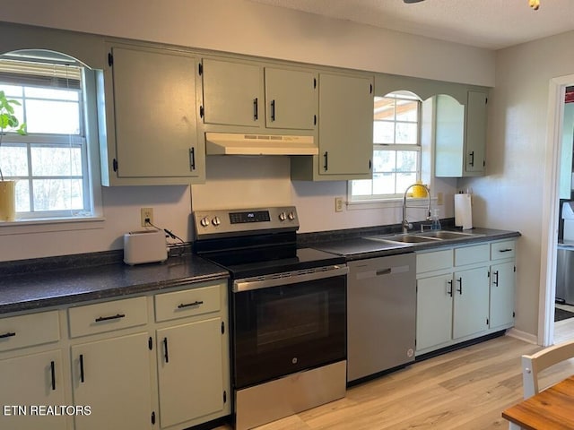 kitchen featuring sink, appliances with stainless steel finishes, light wood-type flooring, and a healthy amount of sunlight