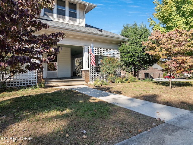 property entrance featuring a lawn and a porch