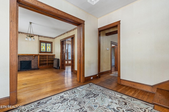 corridor featuring dark wood-type flooring, crown molding, an inviting chandelier, and radiator heating unit