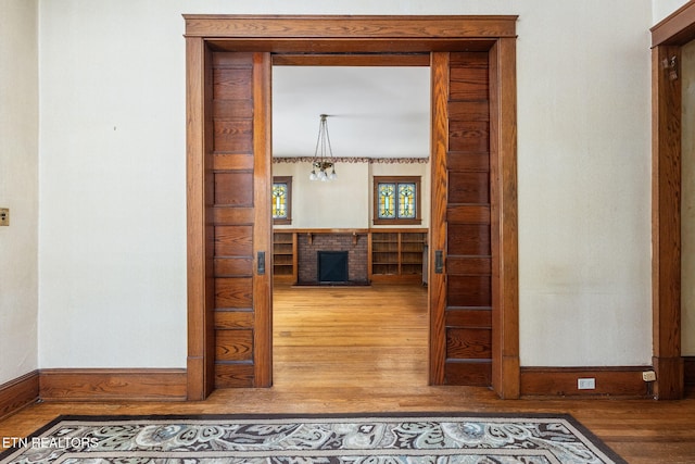 hall featuring a notable chandelier and hardwood / wood-style floors