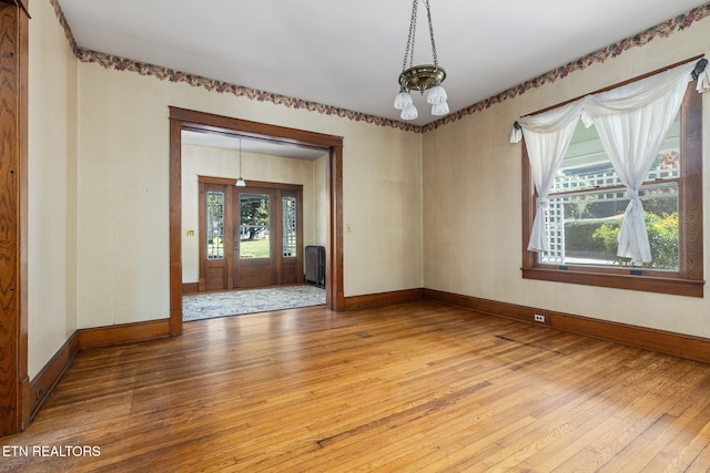 empty room featuring hardwood / wood-style flooring and a chandelier